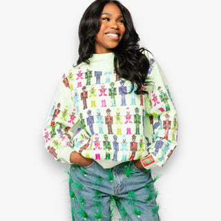 Woman wearing a colorful patterned sweater and jeans on a white background