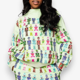 Person wearing a light green sweatshirt with colorful pattern on a white background