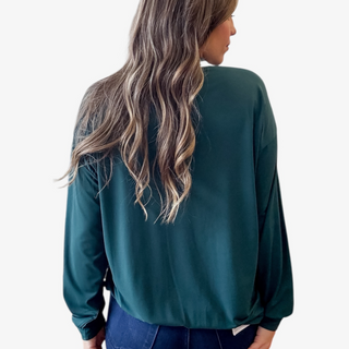 Person wearing a green jacket on a plain background