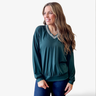 Woman wearing a green long-sleeve top with a white striped collar on a white background