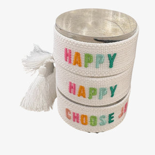 Textured container with colorful 'Happy' text and tassel on a white background
