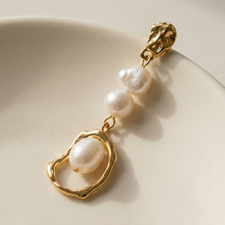Close-up of Alexa Pearl Drop Earrings showing ivory pearls and textured gold details.