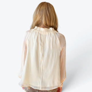 Women's ivory ruffle neck blouse featuring a flowing silhouette, delicate sheer sleeves and gathered high neckline, full back view.