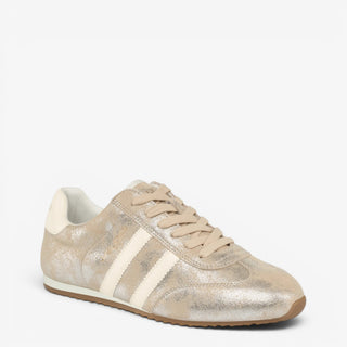 J/Slides Peggy metallic gold sneaker with cream side stripes and gum sole, shown from an angled side view.