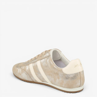 J/Slides Peggy metallic gold sneaker with cream logo heel tab and striped sides, shown from a back angled view.