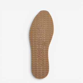 Gum rubber outsole of the J/Slides Peggy metallic gold women’s sneaker with textured tread and logo detail.