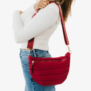 Woman wearing crimson red Jolie Puffer Belt Bag with gold buckle