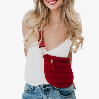 Woman wearing a crimson red Jolie Puffer Belt Bag with gold buckle