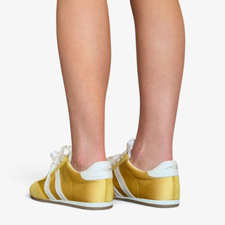 JSlides Peggy yellow sneaker with white heel detail and stripes shown on model, back view