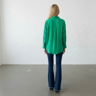 Kelly green button down blouse back view highlighting the relaxed silhouette, curved hem, back yoke, and long sleeves.