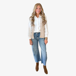 Khaki knit sweater vest for women styled open over a white button down shirt with barrel jeans and brown ankle boots, full-length outfit view.