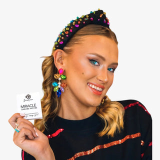 Brianna Cannon Miracle Earlobe Patches held by model to support heavy statement earrings and stretched earlobes.