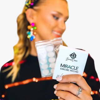 Model wearing colorful statement earrings with Brianna Cannon Miracle Earlobe Patches for invisible support and comfortable all-day wear.