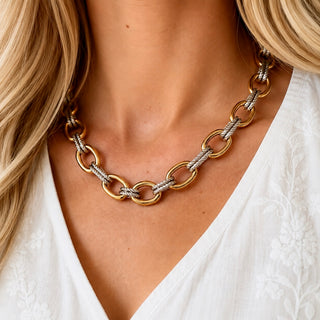 Mixed metal chain necklace with gold and silver links styled on blonde model with white blouse front view