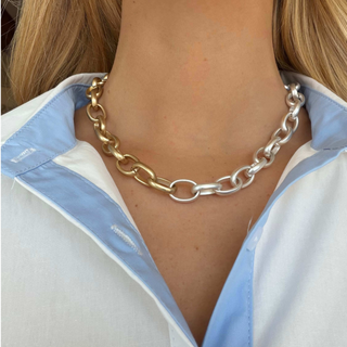 Mixed metal rolo chain necklace with chunky gold and silver links in a two tone design, shown worn in a close-up front view
