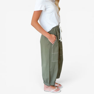 Moss cotton balloon pants with contrast-stitched patch pocket and elastic drawstring waist, angled detail view