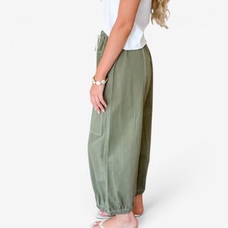 Moss green utility balloon pants with relaxed leg, gathered ankle hem and oversized pocket, side view