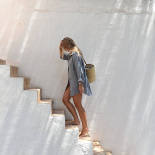 Oversized slate blue linen beach cover up shirt walking staircase lifestyle view