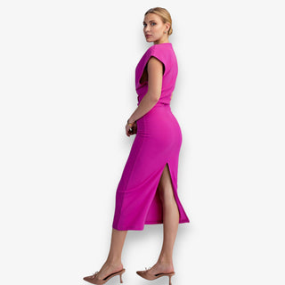 Woman wearing a bright pink dress with a slit on a white background