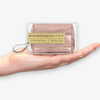 Minimergency kit held in a hand on a white background