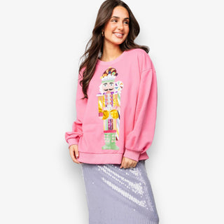 Woman wearing a pink sweatshirt with a colorful design on a white background