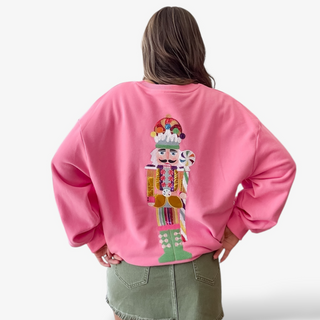 Person wearing a pink sweatshirt with a colorful nutcracker design on the back.