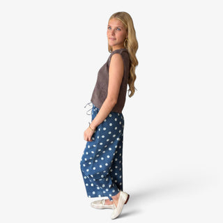 Polka dot denim wide leg pants in blue with white dots and relaxed cropped length, angled side view