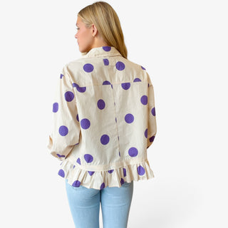 Polka dot ruffle hem shirt in cream and purple featuring a gathered ruffle hem, back view