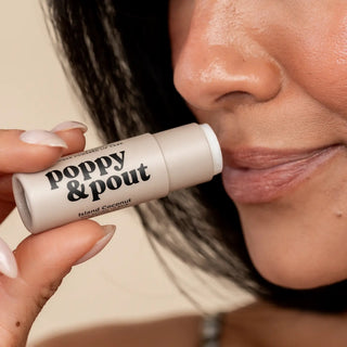 Close-up of woman applying Poppy & Pout Island Coconut natural lip balm for smooth moisturized lips