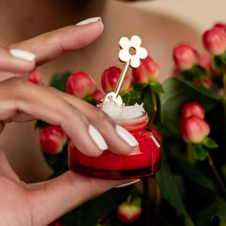 Poppy & Pout Lip Care Spatula shown scooping lip treatment from a jar for convenient hygienic application