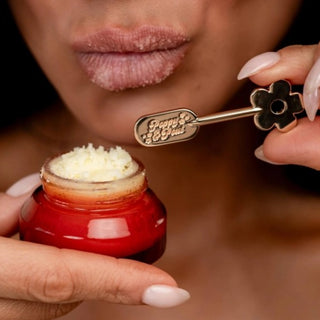 Poppy & Pout Lip Care Spatula being used to scoop lip scrub from a jar for easy mess-free lip care application
