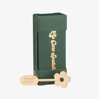 Poppy & Pout Lip Care Spatula in gold displayed with green Lip Care Spatula product packaging