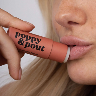 Poppy & Pout Pomegranate Peach Lip Balm being applied to lips for smooth moisturizing everyday lip care