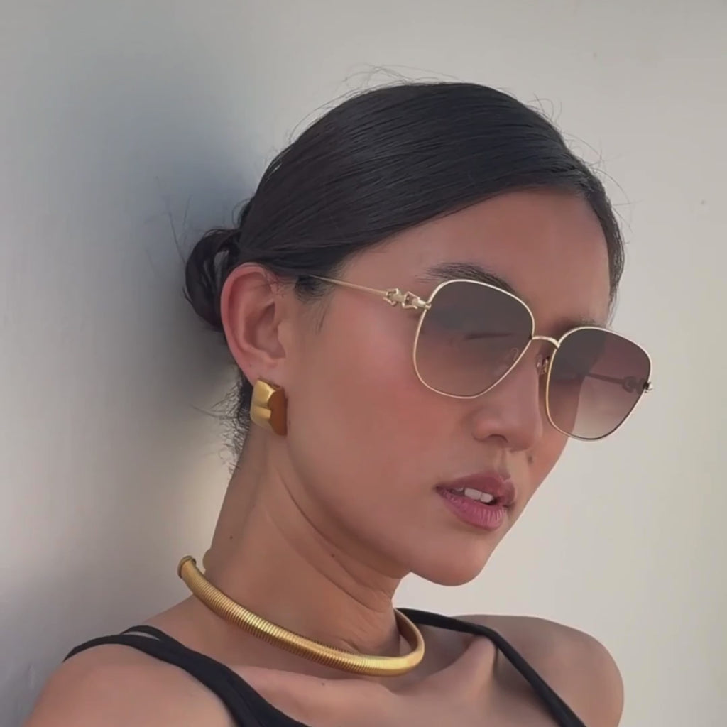 Woman wearing FREYRS Lea gold frame sunglasses with gray gradient lenses in motion video view