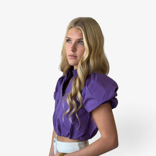 Purple cropped cotton shirt with statement puff sleeves, contrast stitching and elastic hem shown from the side