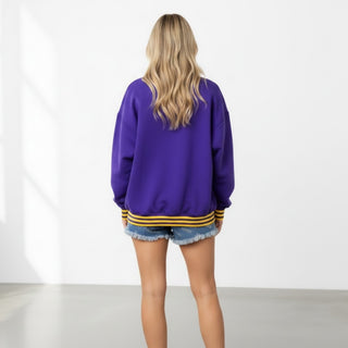 Back view of Queen of Sparkles LSU Metallic Banner Sweatshirt in purple with gold striped ribbed trim and oversized relaxed silhouette.