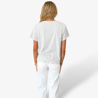 Back view of Queen of Sparkles LSU Metallic Banner Tee in light gray styled with white jeans and a textured gold belt