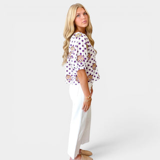 Side view of Queen of Sparkles LSU polka dot top showing purple polka dot side and puff sleeves