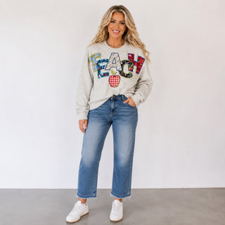 Queen of Sparkles teacher sweatshirt in heather grey with colorful TEACH appliqué and apple graphic styled with blue jeans, front view
