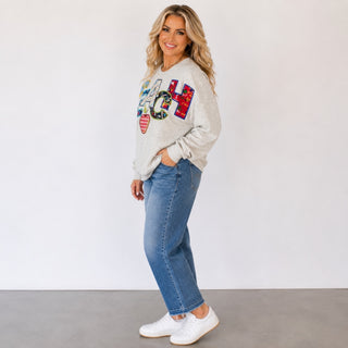 Queen of Sparkles teacher sweatshirt with relaxed fit, colorful school-themed TEACH design and blue jeans, side view.