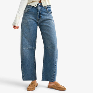 front.jpg	Raw hem barrel jeans in medium wash blue denim with curved seams, styled with an ivory cardigan and suede loafers, front view.