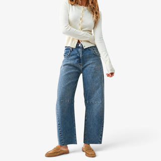 Medium wash raw hem barrel jeans styled with an ivory cardigan and tan suede loafer mules for a casual outfit, full outfit view.