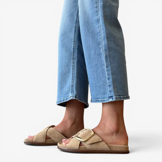 Sam Edelman Darla suede slide sandals in beige with gold buckle detail worn with light wash cropped jeans side view