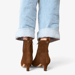 Sam Edelman Peony ankle boot in Warm Nutmeg suede shown from the back with kitten heel and cuffed light wash jeans.