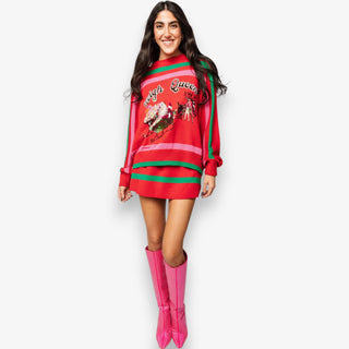 Woman wearing a red Christmas-themed sweater dress with pink boots on a white background