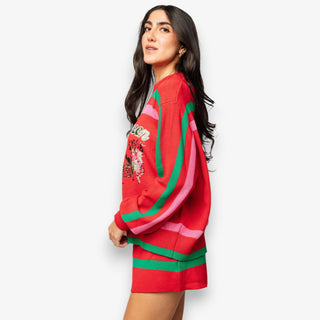 Woman wearing a red sweater with colorful patterns on a white background