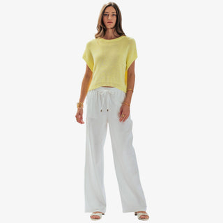     Soft yellow short sleeve knit top styled with white wide leg drawstring pants, shown in a full-length front outfit view.