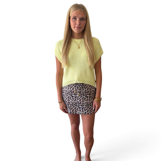 Soft yellow knit top for women with short sleeves and relaxed fit, styled with leopard print skirt, front view