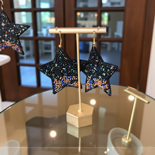 Black star earrings with black beads, iridescent accents, and colorful seed bead details on gold-tone hooks