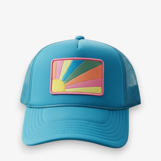 Blue trucker hat with a colorful sun patch on a white background